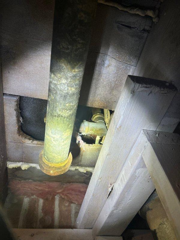 Responded to priority service call for toilet leaking at base. Upon inspection, discovered significant corrosion and mineral buildup on the waste pipe and connection points. Identified compromised wax seal as source of leakage. Replaced wax ring, secured toilet to flange with new bolts, and verified proper seal with no further leakage.