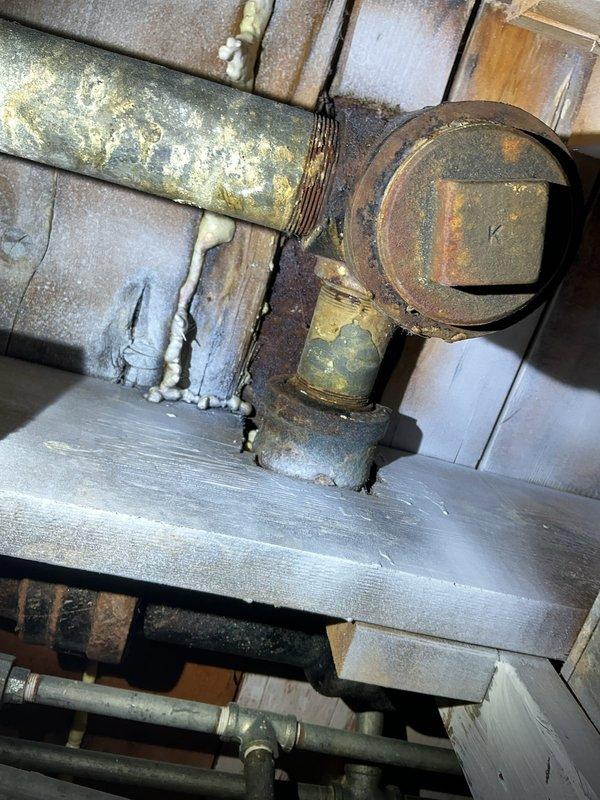 Responded to call back for Jon to inspect deteriorated plumbing infrastructure. Documented significant corrosion and oxidation on main metal pipe with extensive rusting and mineral buildup. Noted damaged insulation with loose fibers around pipe connections in the mechanical space, indicating need for comprehensive repair/replacement of aging system components.