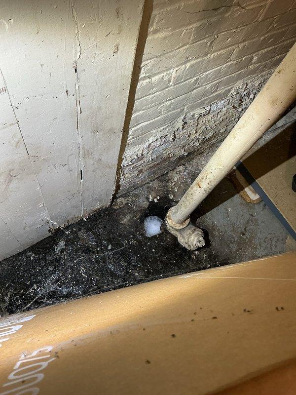 Performed inspection of basement plumbing system after VIP customer reported potential collapsed pipes under floor. Visual assessment revealed catch basin filled with dirt and completely dry. Documented significant water intrusion into basement area with photographic evidence showing deteriorated wall surfaces, visible moisture accumulation at pipe junctions, and crumbling material at the corner where drainage pipe meets floor.