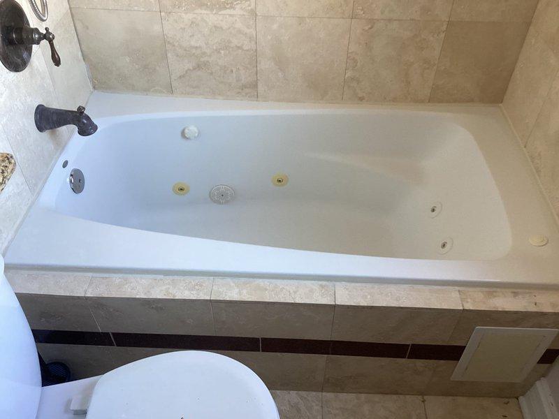 Responded to a callback for Frank Basi to assess jetted bathtub replacement. Inspected existing jacuzzi tub/shower combination with oil-rubbed bronze fixtures and beige tile surround. Documented current installation condition for proper replacement specifications.