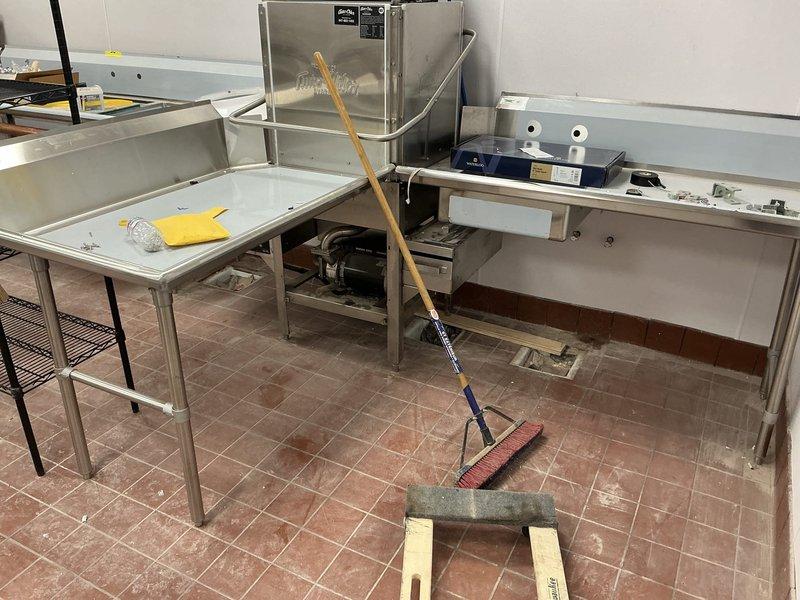 Performed site assessment at commercial property to evaluate requirements for new drain installations for multiple sinks. Inspected existing stainless steel workstations in the kitchen area, noting current drainage configuration and floor access points. Identified necessary connection points to main sewer line through the terracotta-tiled floor where access panel was located. Provided comprehensive estimate for commercial drain installation project.