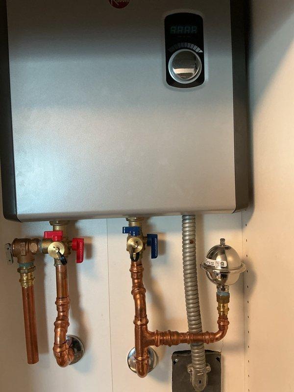 Performed scheduled maintenance flush on 1-year-old residential tankless water heater. Connected service hoses to isolation valves and circulated descaling solution through heat exchanger to remove mineral buildup. System was thoroughly flushed and returned to service with all connections verified secure and operational.