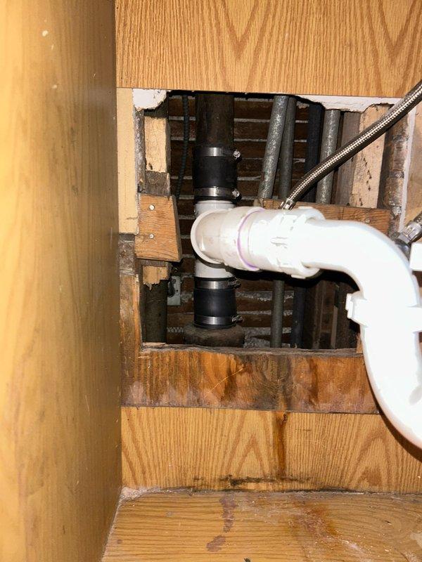 Responded to kitchen sink leak issue causing water damage in basement. Inspection revealed deteriorated PVC drain pipe with failing black coupling fittings. Replaced damaged section of drain pipe and couplings, ensuring proper water-tight connections. Confirmed extensive water damage to wooden joists and recommended customer consult with a remediation specialist regarding the structural water damage.