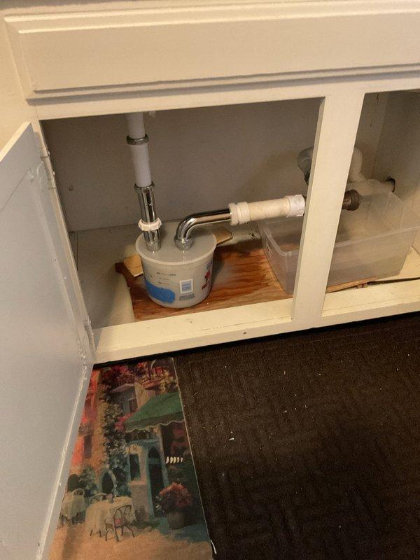 Diagnosed multiple kitchen sink clogs on second and third floors. Cleaned out grease trap under sink but clog persisted. Upon further inspection, identified a water leak from chrome faucet connection requiring containment with collection bucket. Recommended professional drain cleaning service to address persistent clog beyond trap area.