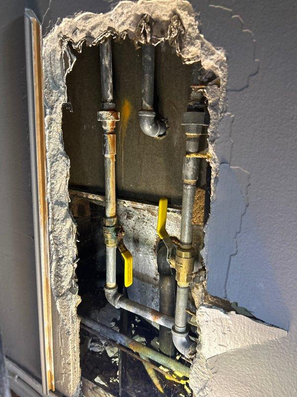 Responded to client complaint about insufficient hot water temperature in shower. Accessed plumbing through wall cavity to inspect the shower valve and water supply lines. Identified oxidation and aging on copper pipes with brass fittings that were restricting proper water flow. Adjusted mixing valve to increase hot water flow capacity, ensuring shower now reaches appropriate temperature.