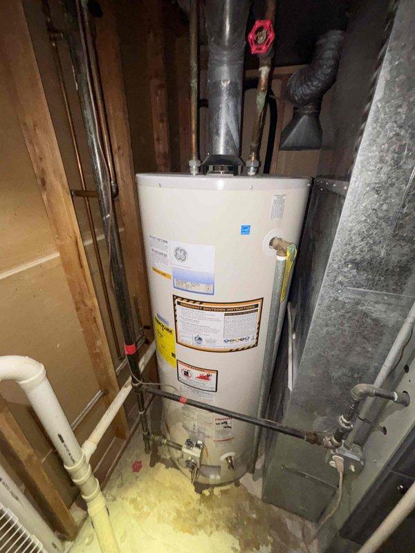 Conducted an estimate for replacement of existing GE 50-gallon gas water heater (40,000 BTU) located in utility closet with significant water staining evident on surrounding framing. Inspection revealed copper supply lines with shut-off valves, proper venting system, and possible minor leakage near base of current unit. Customer advised of replacement options and availability beginning 8AM.