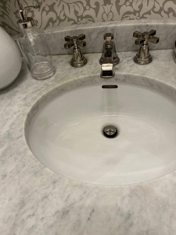 Successfully completed installation of new bathroom vanity to replace the previously cracked unit. Properly connected all plumbing components including P-trap and drain assembly. Verified proper installation of oval basin with chrome fixtures and ensured no leaks in the system.