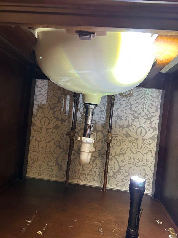 Successfully completed installation of new bathroom vanity to replace the previously cracked unit. Properly connected all plumbing components including P-trap and drain assembly. Verified proper installation of oval basin with chrome fixtures and ensured no leaks in the system.