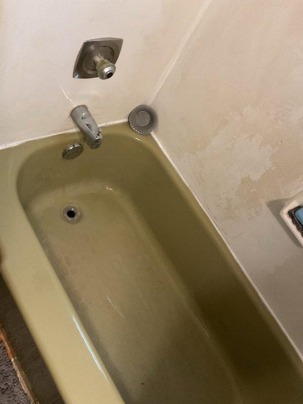 Cleared solid blockage from discolored shower drain in older bathtub. Observed significant mineral buildup and staining throughout the basin. Drain now functioning properly with improved water flow.