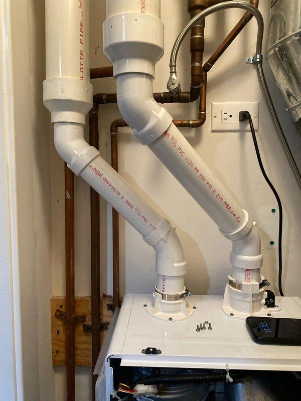 Completed installation of a tankless water heater system with new copper supply lines and a water filtration system with clear housing. Also installed PVC drainage pipes with appropriate elbow joints for washing machine connection, ensuring proper drainage and supply functionality.