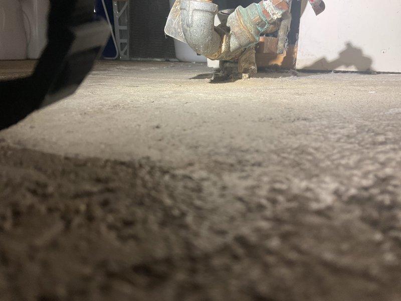 Responded to first morning service call sold by Joey. Upon inspection, found water heater/hot water appliance in utility area with corroded plumbing connections and evidence of moisture damage on concrete floor. Documented existing conditions with photos before proceeding with necessary repairs.