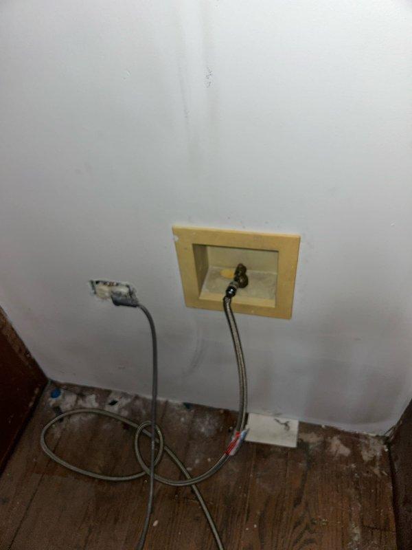 Installed new water shut-off valve behind refrigerator and inspected hot water line configuration. Verified connection integrity of braided supply line to wall access panel. Confirmed proper operation of red-handled shutoff valve on copper piping system.
