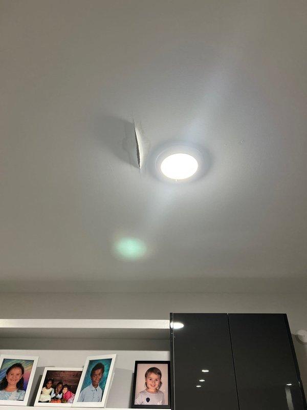 Conducted leak inspection in response to customer's concern about water damage appearing on kitchen ceiling below washing machine. Visual assessment revealed ceiling damage near recessed lighting, including visible tearing/cracking in drywall consistent with water intrusion. Performed thorough examination of plumbing connections at washing machine location to identify source of leak.