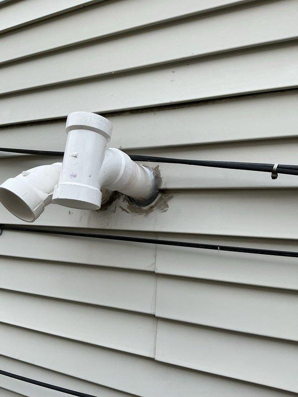 Completed gas repipe at front of house, relocated slop sink against wall, and sealed exterior pipe penetration with spray foam and silicone. Installed various sized nipples (24", 36", 48") to complete the installation and ensure proper gas supply to resolve intermittent hot water issues.