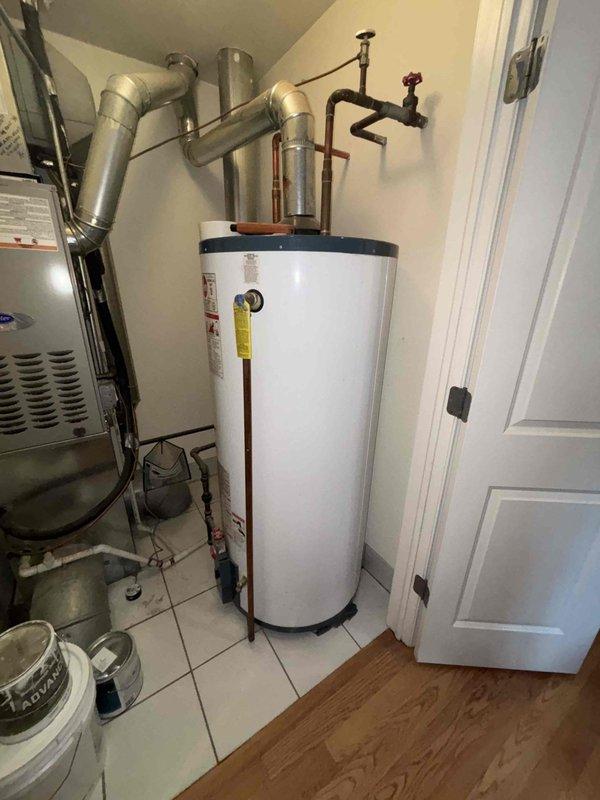 Inspected 20+ year old 75-gallon water heater exhibiting active leakage from top connections. Unit shows significant age deterioration with discolored copper pipes and deteriorating connections. Recommended full replacement due to tank age and active leak condition.