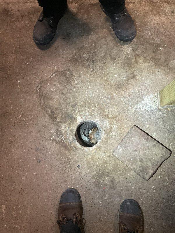 Performed site assessment on concrete floor drain showing significant mineral buildup and water staining around drain opening. Conducted inspection of drainage system and provided customer with hydrojetting options to clear blockage and restore proper drainage function. Floor drain showed evidence of prolonged water exposure requiring professional intervention.