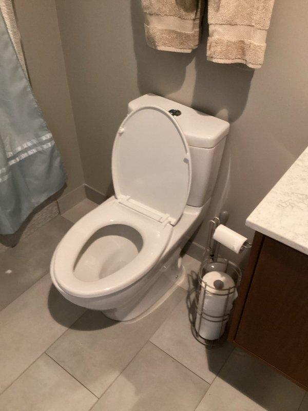 Conducted water leak investigation in bathroom, focusing on toilet area. Performed visual inspection of toilet components and surrounding fixtures. No active leaks identified during inspection; toilet appears to be functioning properly with no signs of water damage around base or supply line. Photos documented for reference.