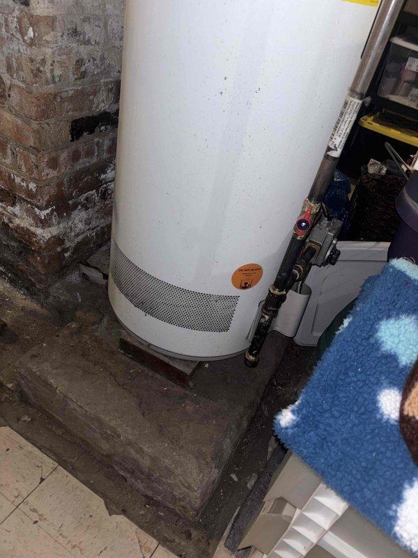 Responded to callback for customer Basi at request of Kevin. Inspected water heater installation in basement utility area, noting proper copper pipe connections and valve placement. Examined ceiling PVC drainage system, identifying signs of previous water damage on surrounding wooden joists and planks. Documented installation conditions with photos for service record.
