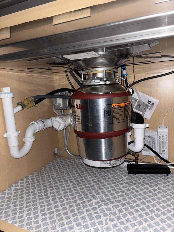Responded to emergency service call for non-functioning kitchen faucet. Upon inspection, installed new Waste King garbage disposal unit with complete PVC drainage system. Checked copper pipe connections for proper installation and ensured all electrical components were securely wired and functioning correctly.