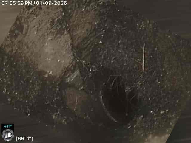 Responded to callback for Jon. Performed camera inspection of sewer line, documenting conditions at 59'3" and 66'1" depths where potential blockage or damage was identified. Images revealed rough, irregular surfaces with debris accumulation in the pipe interior.