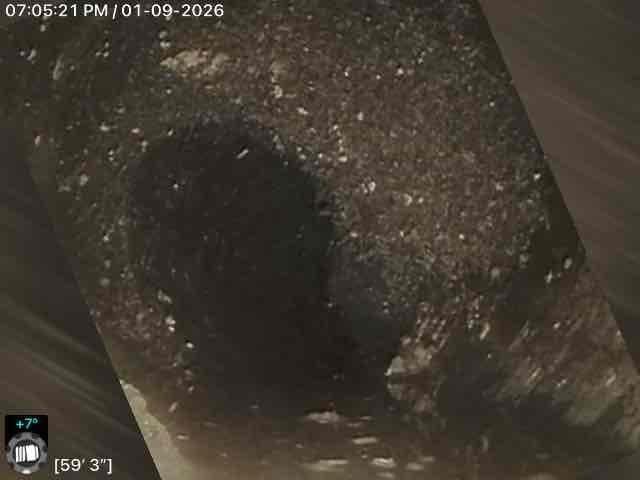 Responded to callback for Jon. Performed camera inspection of sewer line, documenting conditions at 59'3" and 66'1" depths where potential blockage or damage was identified. Images revealed rough, irregular surfaces with debris accumulation in the pipe interior.