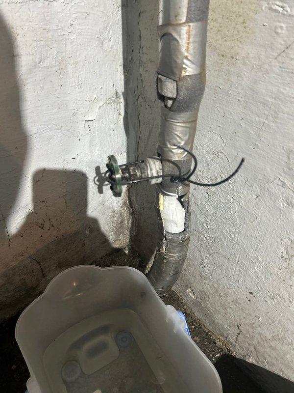 Inspected main valve leak issue that occurs during operation. Confirmed that city has located the boundary box and completed their portion of work. Customer is awaiting tree removal before final resolution. Documented condition of exterior utility markings and interior plumbing setup with valve installation.