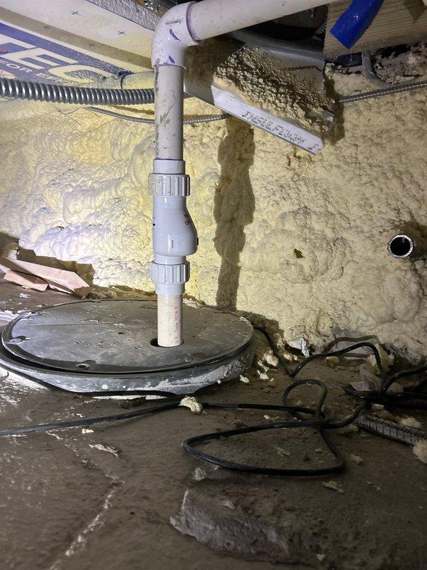Inspected non-functioning sump pump in crawl space which was producing buzzing noise without pumping action. Examination revealed clogged discharge pipe and worn impeller assembly requiring replacement. Installed new sump pump with upgraded check valve and verified proper water evacuation through PVC discharge piping.