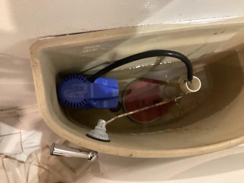 Responded to building shutdown service call. Inspected toilet mechanisms including Korky fill valve assembly and flush valve components. Documented condition of tank interior showing mineral deposits and water staining. Tank components appear functional.