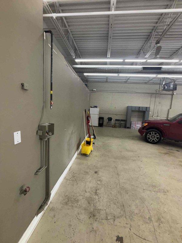 Conducted site assessment for soak sink installation in commercial garage/workshop space. Evaluated existing plumbing connections with hot and cold water valves and determined necessary fixture placement. Location features concrete flooring and adequate wall space for proper mounting and drainage requirements.
