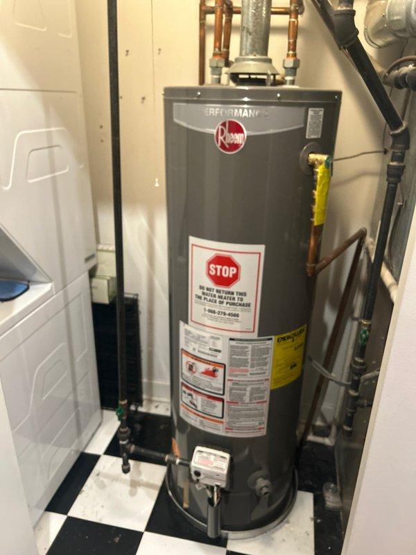Responded to emergency service call for active water heater leak. Diagnosed a failing Rheem water heater unit with corroded copper pipe connections. Replaced defective unit with new Bradford White water heater, installed blue expansion tank, and replaced deteriorated pipe sections. All connections were pressure tested and system was restored to full operation with no leaks detected.