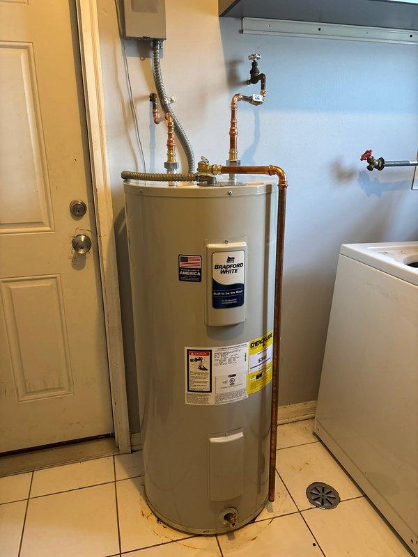 Successfully completed installation of new Bradford White residential water heater in utility room. Properly connected all copper supply and output lines with brass fittings and ensured proper electrical connection via junction box. Installation includes appropriate valving and all connections have been tested for proper operation.