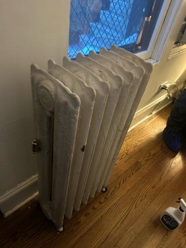 Serviced and inspected classic white cast iron radiator system. Identified and repaired door latch mechanism in adjacent doorway. All components now functioning properly with improved performance verified during final inspection.