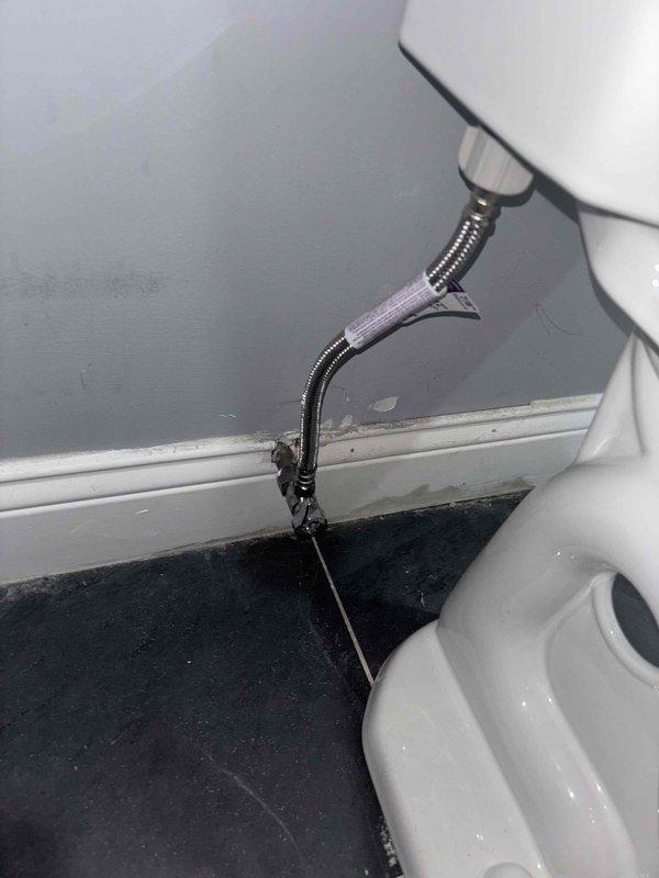 Performed comprehensive assessment of client's plumbing service requests including: evaluation of leaking toilet shut-off valve requiring replacement, assessment of kitchen area for new garbage disposal installation requiring initial setup, inspection of existing plumbing infrastructure to determine options for whole-home water filtration systems, and evaluation of toilet fixtures for potential bidet installation. Documented current plumbing conditions with photos showing existing water supply lines and PVC drainage system with visible primer markings at joints.