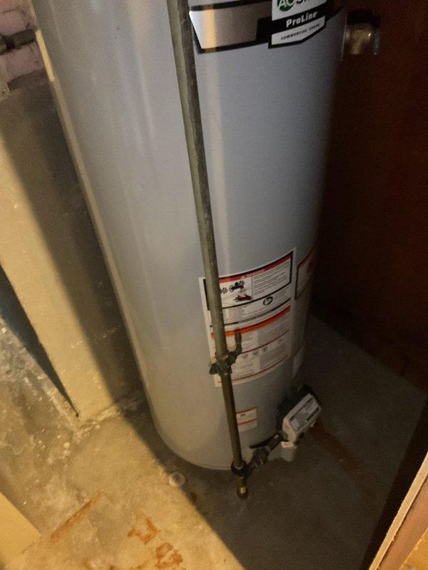 Inspected aging tank-style water heater (10-20 years old) and remedied two safety issues: installed missing temperature and pressure relief (T&P) valve discharge pipe and adjusted improper water heater vent piping to ensure proper exhaust flow.