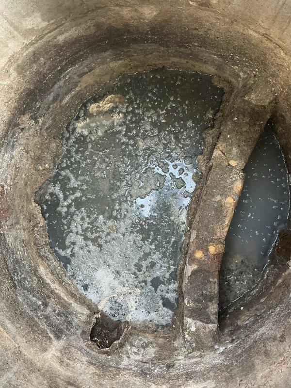 Responded to priority service call for an actively backing up catch basin. Upon inspection, discovered significant rust and corrosion inside the drainage pipe with standing water at the bottom. Cleaned the catch basin thoroughly, removing accumulated sediment and debris from the concrete chamber that was causing the blockage and backup issues.