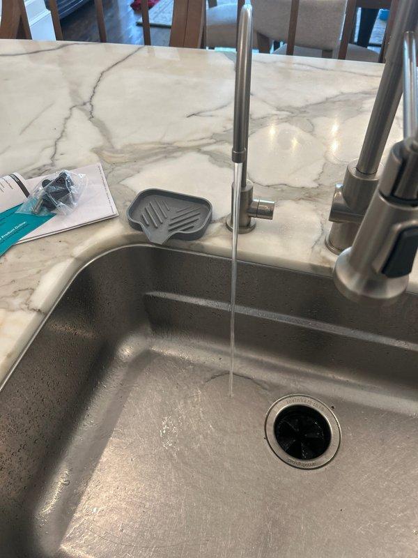 Successfully installed and connected a multi-stage water filtration system in the kitchen cabinet. System was properly mounted to cabinet wall and connected to existing plumbing, with operational testing confirming proper water flow through the new filtration unit.