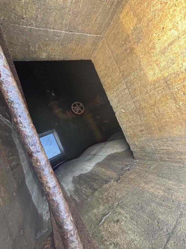 Conducted site inspection of four stuck water valves (4" or 5") in utility access area. Documented extensive pipe corrosion and deterioration within concrete enclosure. Photographed valve wheels showing significant rust and aging in difficult-to-access utility tunnel. Prepared quotation for valve replacement/repair as requested by client.