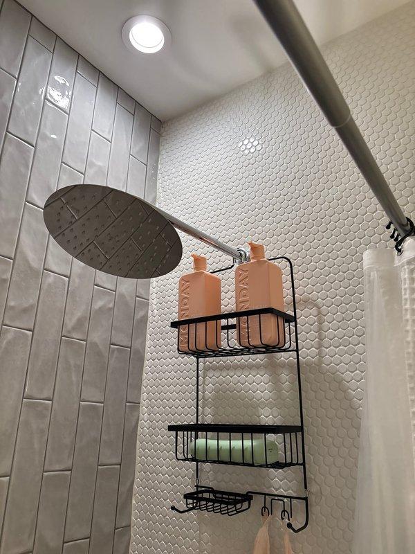 Responded to priority service call regarding bathtub leakage from base and through wall. Upon inspection of the modern bathroom with dual-tile design (subway pattern and hexagonal mosaic), identified faulty shower valve control fixture causing water penetration behind walls. Repaired valve assembly and sealed connection points to prevent further leakage.