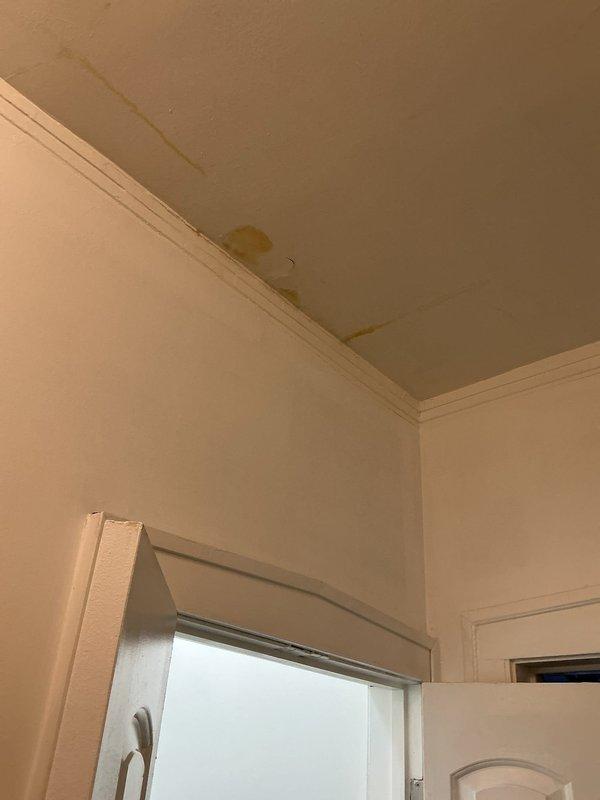 Conducted leak investigation in response to customer's report of a leak near washing machine and drain odor issues during rain or appliance use. Inspection revealed significant water damage on ceiling with yellowish-brown staining near crown molding, indicating active leak. Accessed mechanical area to examine plumbing connections, including flexible ducts and colored supply lines. Determined source of leak and addressed drainage issue causing odors.