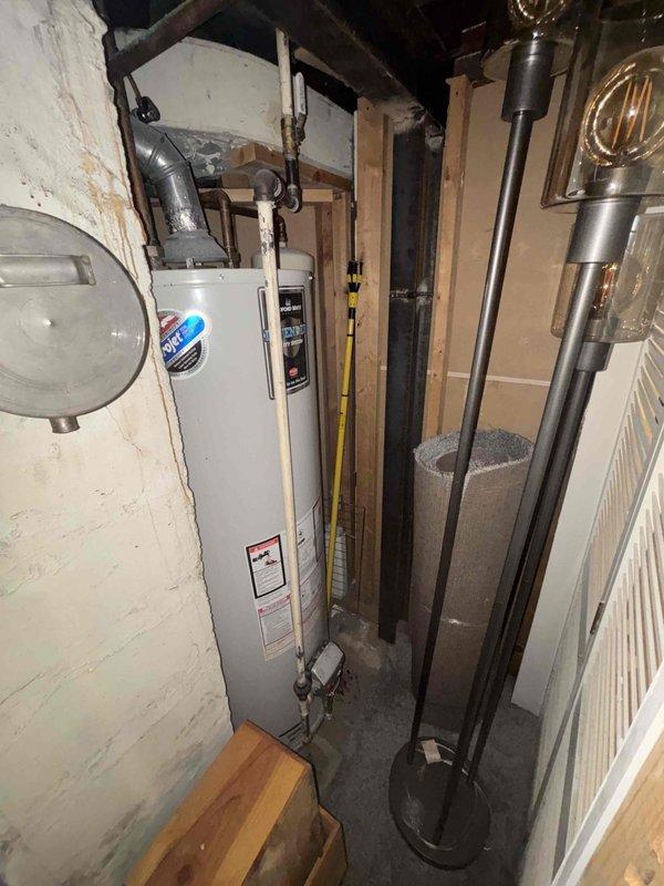 Conducted inspection of existing water heater system in utility closet requiring replacement. Observed significant corrosion and mineral buildup on connecting pipes and valve assembly. Provided comprehensive estimate for water heater replacement including removal of old unit, along with separate estimates for toilet replacement and installation of refrigerator water line as requested by customer.