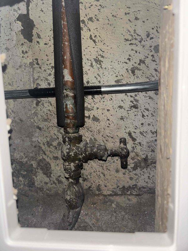 Conducted inspection of existing water heater system in utility closet requiring replacement. Observed significant corrosion and mineral buildup on connecting pipes and valve assembly. Provided comprehensive estimate for water heater replacement including removal of old unit, along with separate estimates for toilet replacement and installation of refrigerator water line as requested by customer.