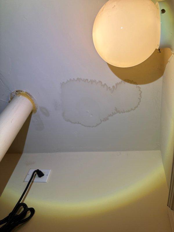 Inspected water damage in ceiling underneath bathroom. Located active leak from shower fixture in upstairs bathroom, visible as brown staining on ceiling below. Found multiple contributing issues including loose shower valve connections and slow-draining kitchen sink with dishwasher backup. Tightened shower connections and verified proper water temperature regulation after repairs.