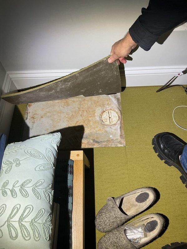 Inspected sump pump system in residential basement after removing carpet access panel. Observed standing water in the sump pit with current pump system and backup power supply in place. Provided estimate for recommended service.