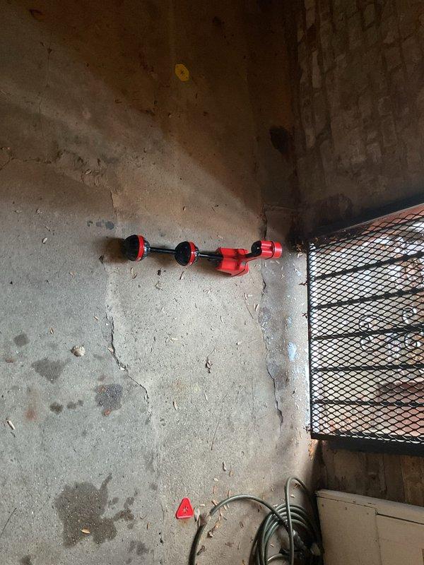 Responded to a clogged drain service call. Inspected aging copper plumbing system showing significant oxidation and a deteriorating cylindrical component with rust damage. Successfully cleared the blockage using specialized drain cleaning equipment in the basement utility area.