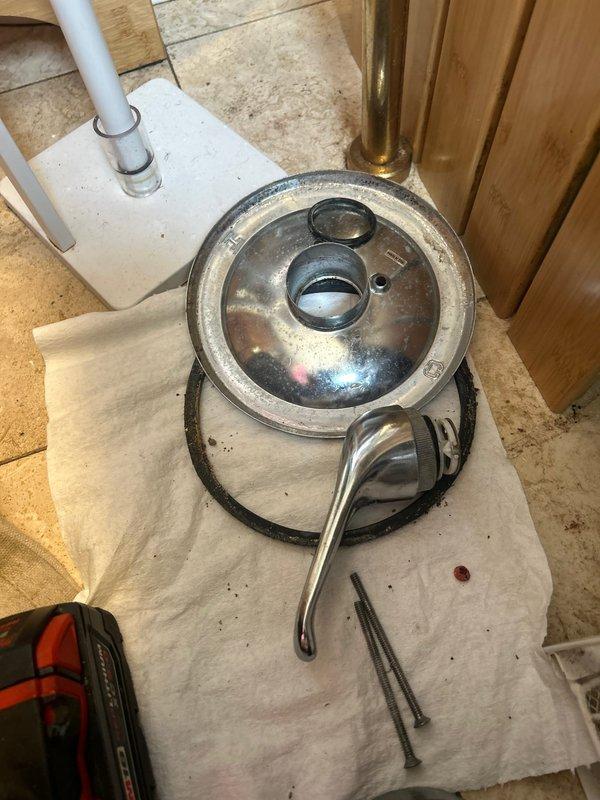 Responded to service call regarding shower handle leakage causing water intrusion to unit below. Disassembled shower/tub fixture, removed faulty cartridge from the valve assembly, and installed new replacement cartridge with proper sealing gasket. Verified proper operation with no leaks after reassembly and testing.