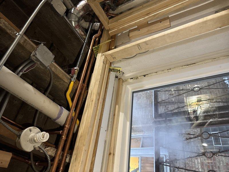 Performed callback inspection of copper supply lines and gas piping in basement utility area. Examined window framing with exposed plumbing infrastructure and evaluated condition of copper pipes running between floor joists. Documented installation with photos for further assessment as requested by Chris L.