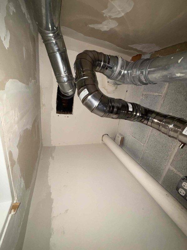 Completed installation of customer-supplied tankless water heater in mechanical room. Installed and connected necessary ventilation ductwork with proper metal elbow joints and fasteners. Ensured proper PVC pipe connections for water supply and drainage.