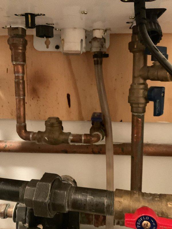 Completed warranty service by installing a new neutralizer unit and vinyl tubing on customer's HVAC/plumbing system. Replaced deteriorated components under the sink area and ensured proper drainage connections to address previous water damage issues. All work performed under lifetime workmanship warranty.