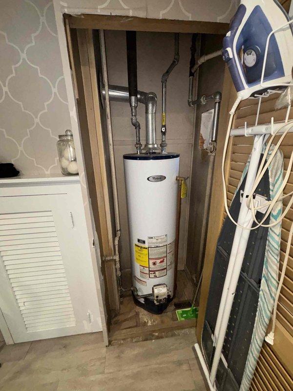 Responded to customer complaint of insufficient hot water during cold weather. Inspected tanked water heater installation in utility closet and examined associated plumbing connections. Determined temperature setting was inadequate for winter conditions and adjusted thermostat to compensate for colder incoming water temperature, restoring proper hot water supply.