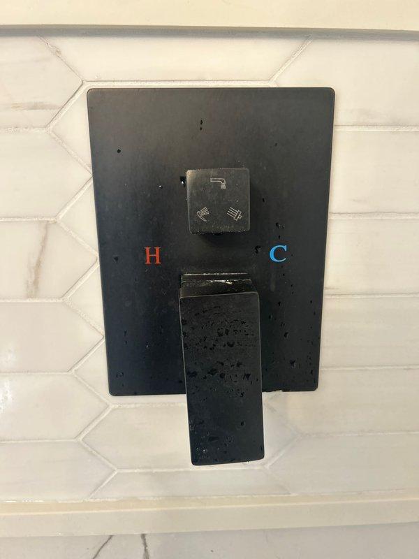 Installed new modern black thermostatic shower valve with dual hot and cold controls on white tiled wall. System includes a ceiling-mounted square black rainfall showerhead with multiple water distribution points, completing the contemporary bathroom fixture upgrade as sold by Jacob.